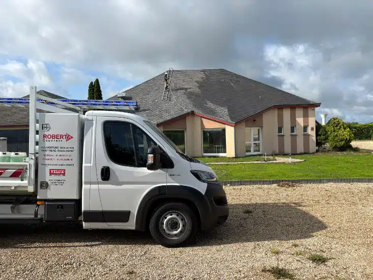 Camion Robert Couvreur devant un chantier de nettoyage de toiture, échelle de couvreur posée sur le toit