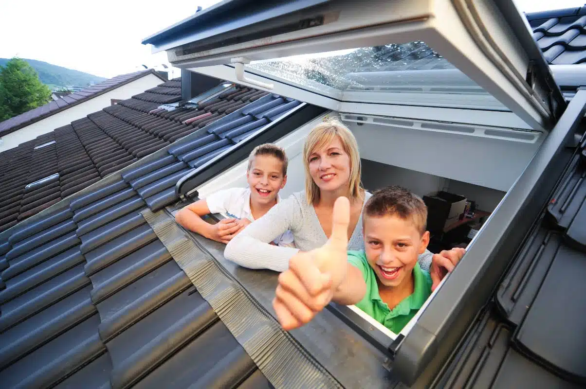 Famille à une fenêtre de toit posée par un installateur Velux