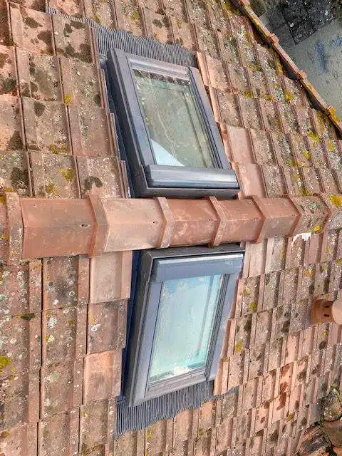 Fenêtre de toit Velux posée sur une couverture en tuiles