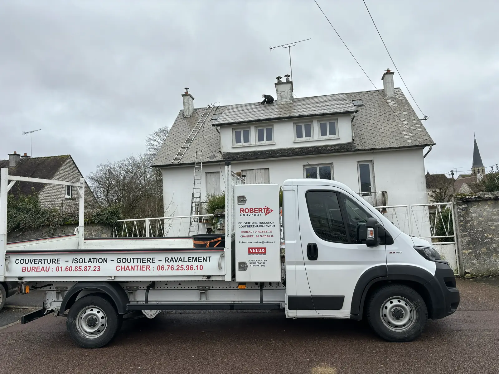 Camion Robert Couvreur devant une maison, réparation de toiture en cours sur le toit — prestation proposée à Chilleurs-aux-Bois